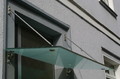 Bild von einem Glasvordach mit matter Folie und Edelstahlhaltern